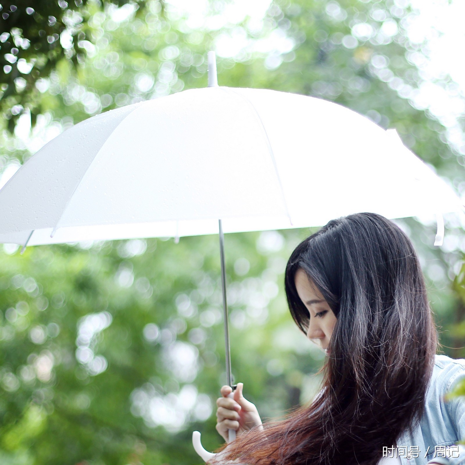 在雨中有一位撑着伞的美丽姑娘在等待!