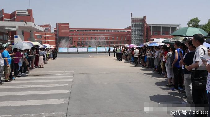 家长围成大圈等待考生 为第一个出考场的男孩