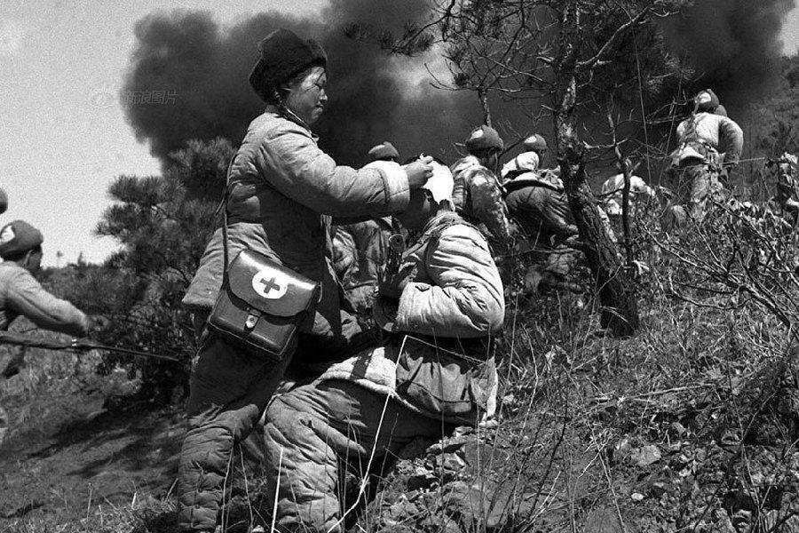 抗美援朝战场上,一名医护人员在炮火中救护伤员.