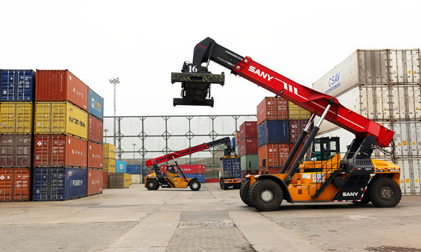 4月20,在日照港集装箱站,工作人员正在装卸集装箱.